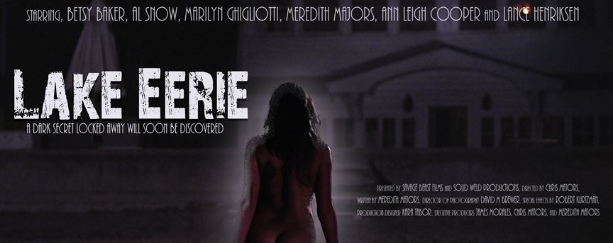 Movie poster for 'Lake Eerie' featuring a mysterious woman standing by a lake with a dark building in the background, highlighting themes of suspense and horror.