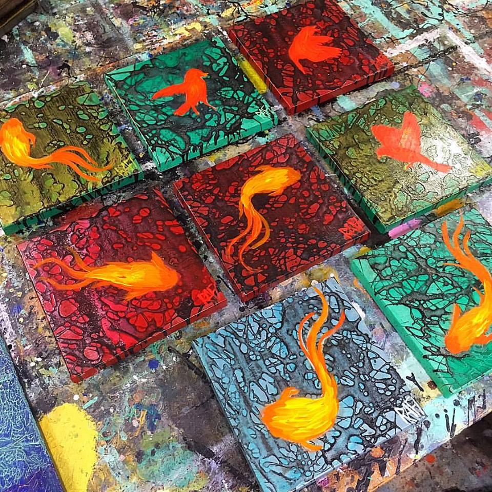 Colorful abstract artwork featuring small orange fish on various textured backgrounds in red, green, and blue hues.
